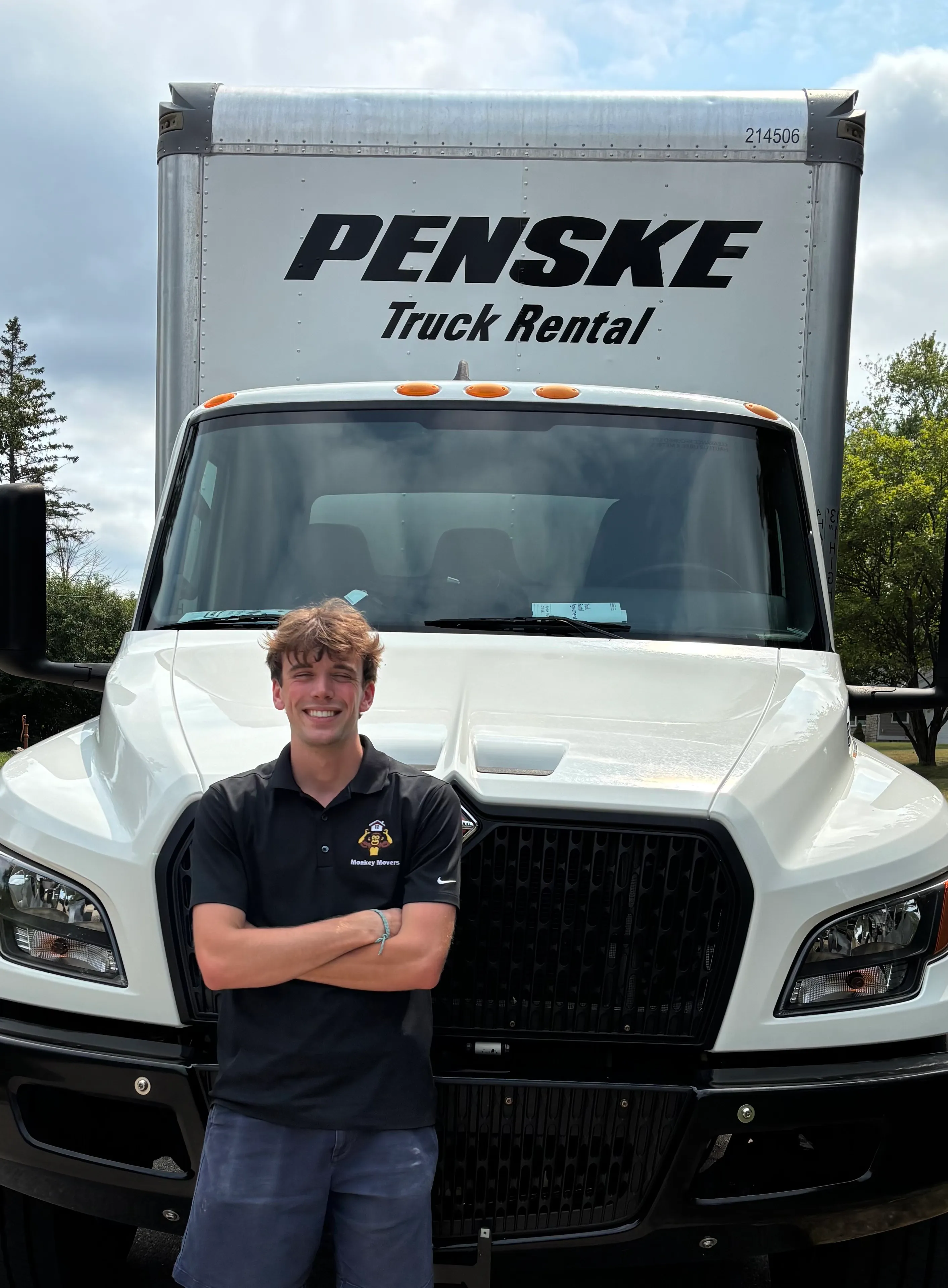 Monkey Movers owner in a company polo in front of a Penske moving truck in Milwaukee